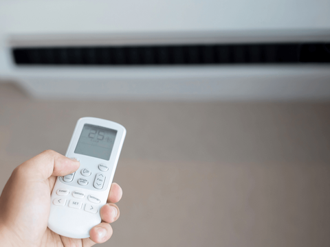 person holding an ac remote control